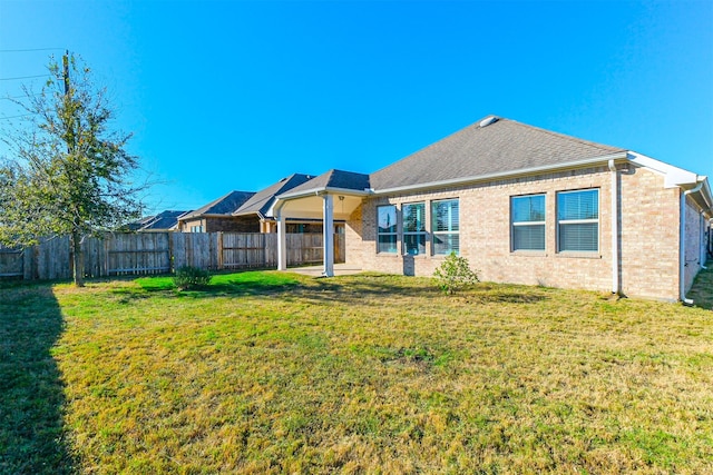 rear view of property featuring a yard