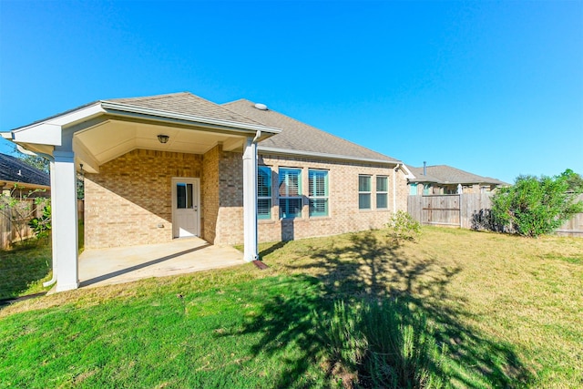 rear view of house featuring a patio area and a lawn