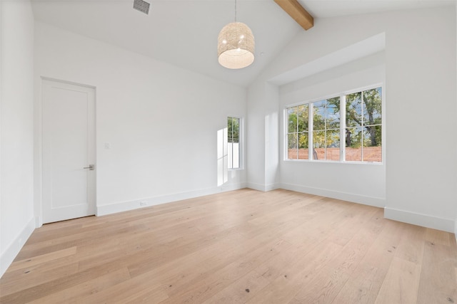 empty room with high vaulted ceiling, beamed ceiling, and light hardwood / wood-style flooring