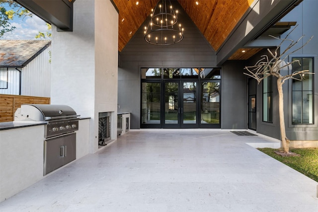 doorway to property with an outdoor kitchen, french doors, and a patio