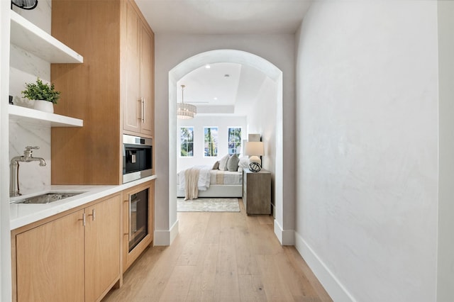 hallway with sink and light hardwood / wood-style floors