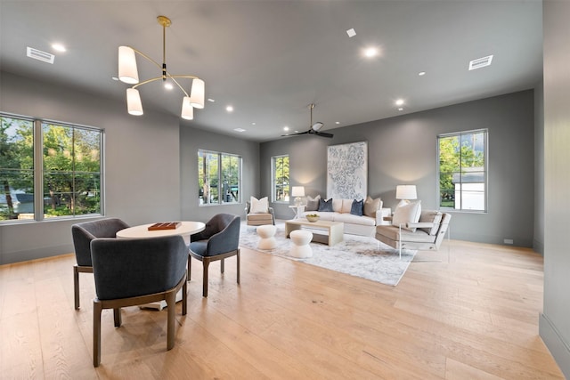 interior space with light hardwood / wood-style flooring and ceiling fan with notable chandelier