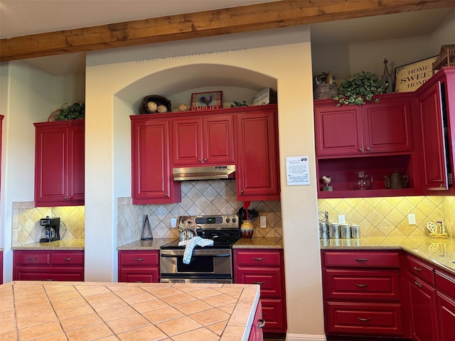 kitchen featuring beam ceiling, tasteful backsplash, tile counters, and stainless steel range with electric stovetop