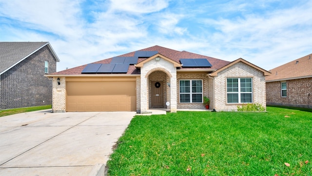 view of front of home with solar panels, a front yard, and a garage