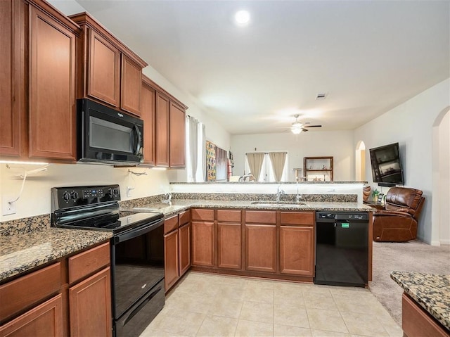 kitchen featuring light stone countertops, ceiling fan, sink, light tile patterned flooring, and black appliances