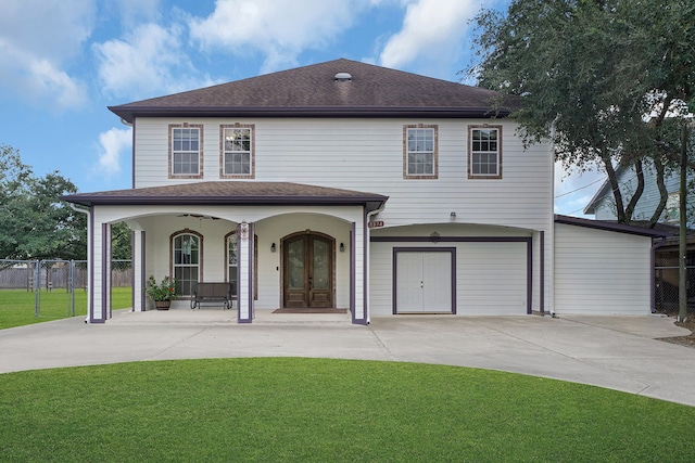 view of front of house with a front yard, french doors, and a garage