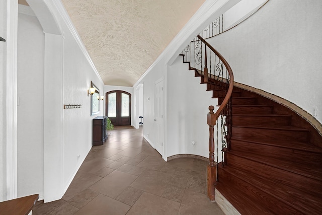 entrance foyer featuring crown molding, a textured ceiling, and french doors