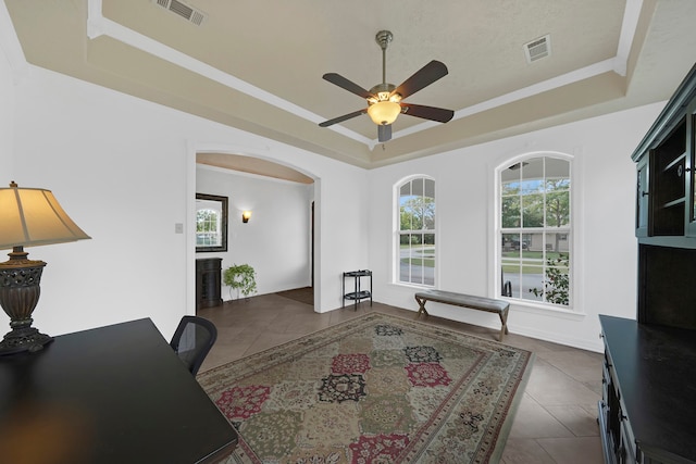 office with dark tile patterned flooring, ceiling fan, and a raised ceiling