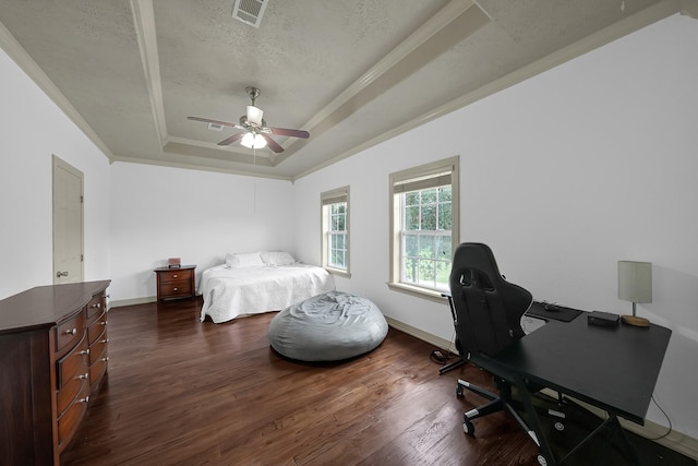 bedroom with a textured ceiling, ceiling fan, a raised ceiling, and dark wood-type flooring