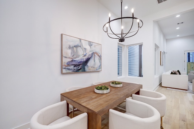 dining area with a chandelier and light hardwood / wood-style floors