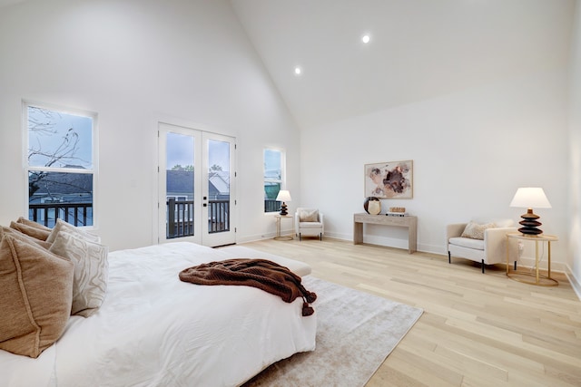 bedroom featuring light hardwood / wood-style flooring, access to outside, high vaulted ceiling, and french doors