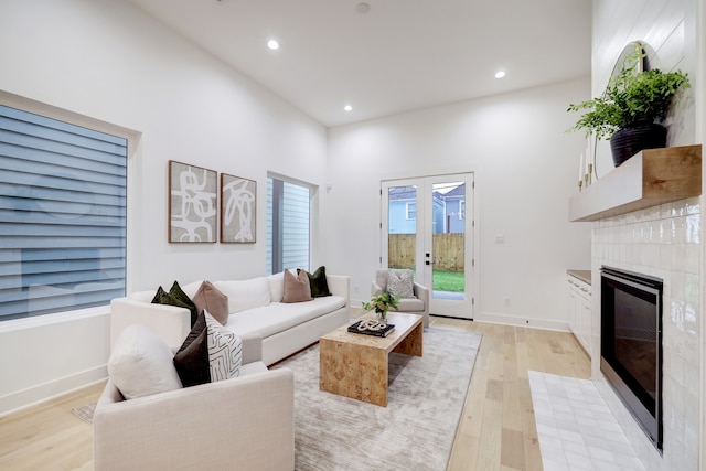 living room featuring a fireplace, light hardwood / wood-style floors, and french doors