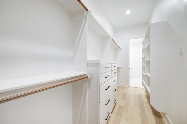 walk in closet with light hardwood / wood-style flooring