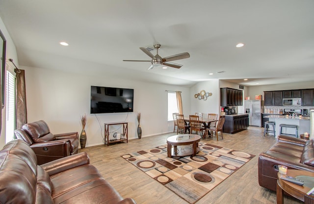 living room with ceiling fan and light hardwood / wood-style flooring