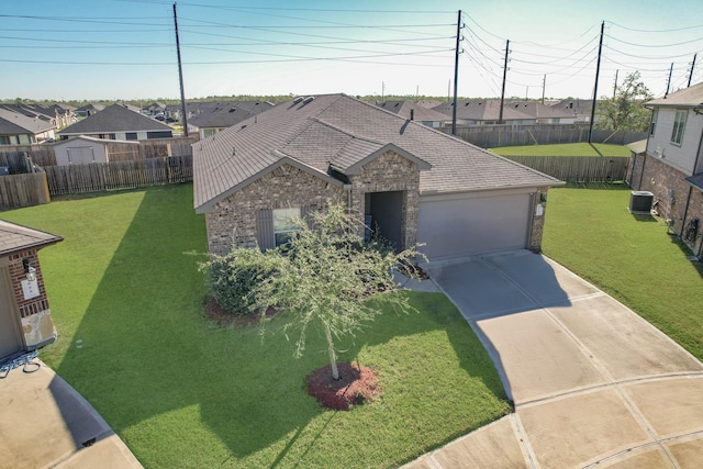 ranch-style home with a front lawn, central AC unit, and a garage