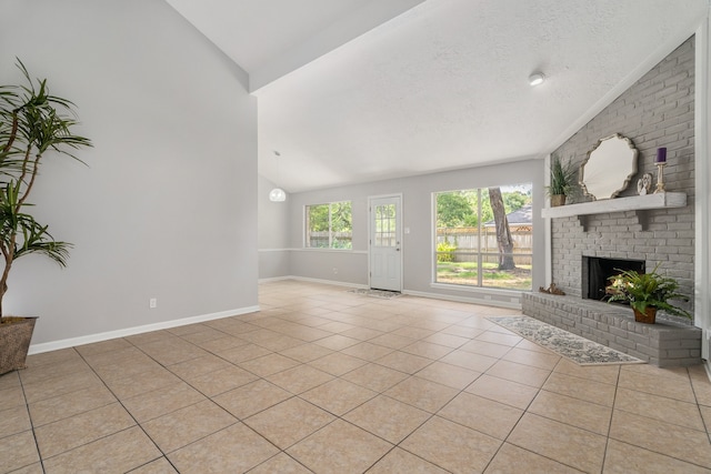 unfurnished living room with a textured ceiling, a fireplace, light tile patterned floors, and vaulted ceiling