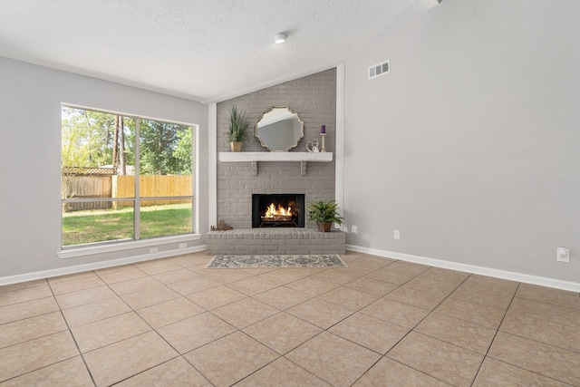 unfurnished living room featuring a fireplace, light tile patterned floors, a textured ceiling, and vaulted ceiling