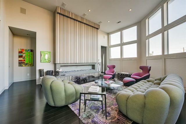 living room featuring dark hardwood / wood-style floors and a towering ceiling