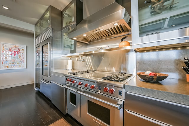 kitchen with decorative backsplash, range with two ovens, dark hardwood / wood-style floors, and wall chimney range hood