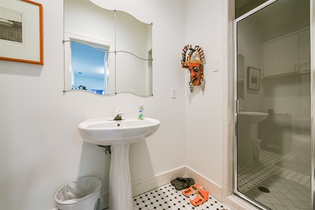 bathroom featuring tile patterned floors, toilet, and an enclosed shower