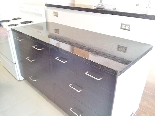 kitchen featuring white electric range oven and light tile patterned flooring