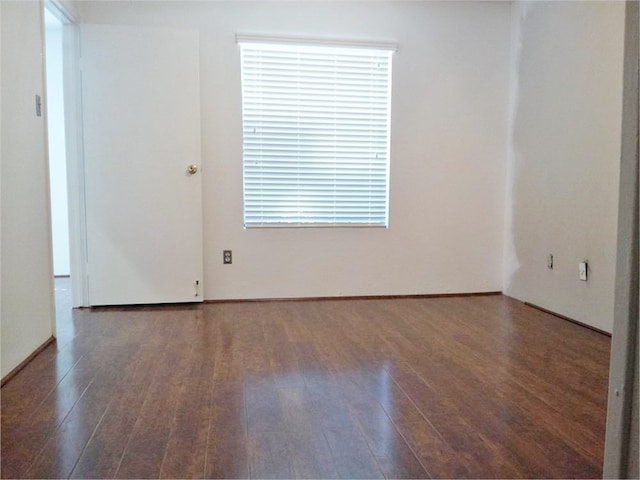 unfurnished room with dark wood-type flooring