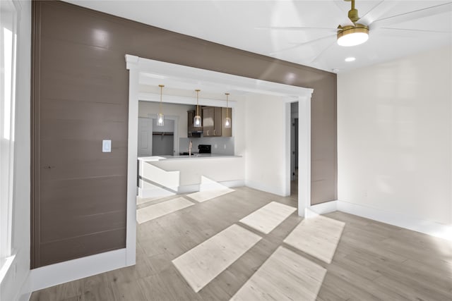 unfurnished living room with light hardwood / wood-style flooring and sink