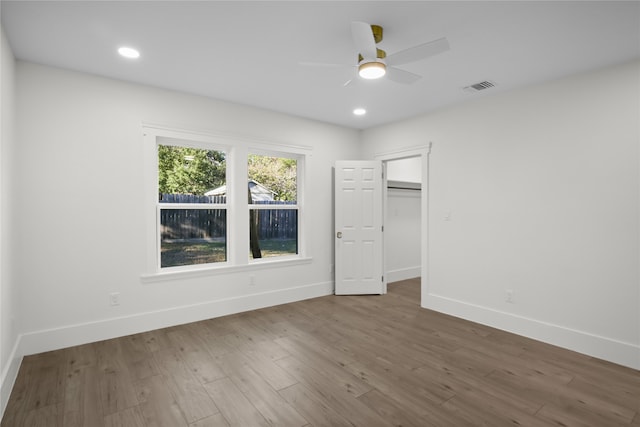 unfurnished bedroom featuring hardwood / wood-style flooring, ceiling fan, and a closet