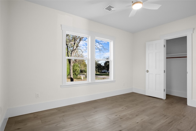 unfurnished bedroom with ceiling fan, a closet, and light hardwood / wood-style flooring