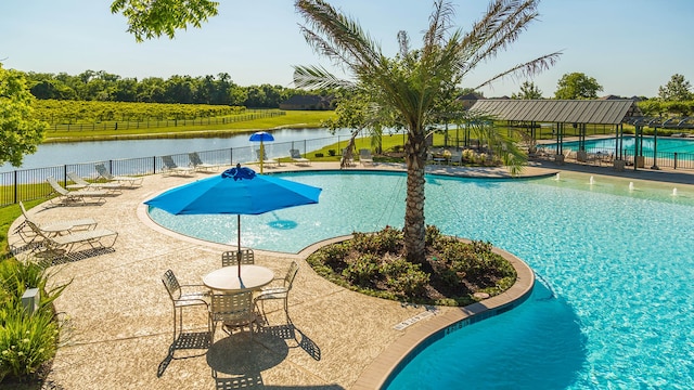 view of swimming pool with a patio area and a water view