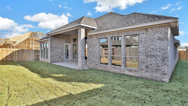 rear view of house with a patio and a lawn