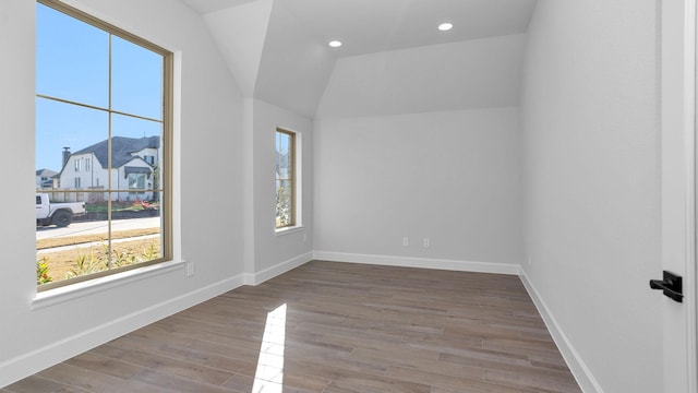 empty room with lofted ceiling and light hardwood / wood-style floors