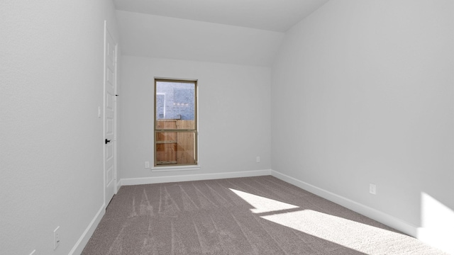 unfurnished room with lofted ceiling and carpet flooring