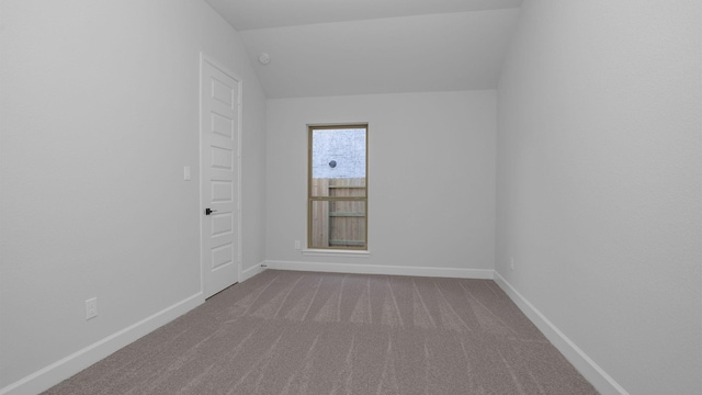 empty room with vaulted ceiling and carpet floors