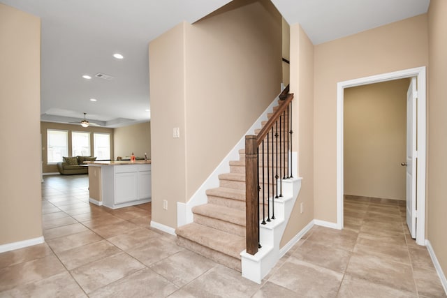 stairs featuring tile patterned flooring and ceiling fan