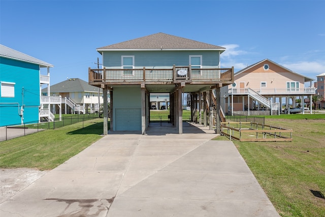 view of front of property with a front lawn, a garage, a carport, and a wooden deck