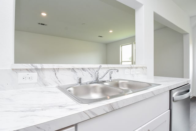 kitchen with decorative backsplash, sink, and white cabinets