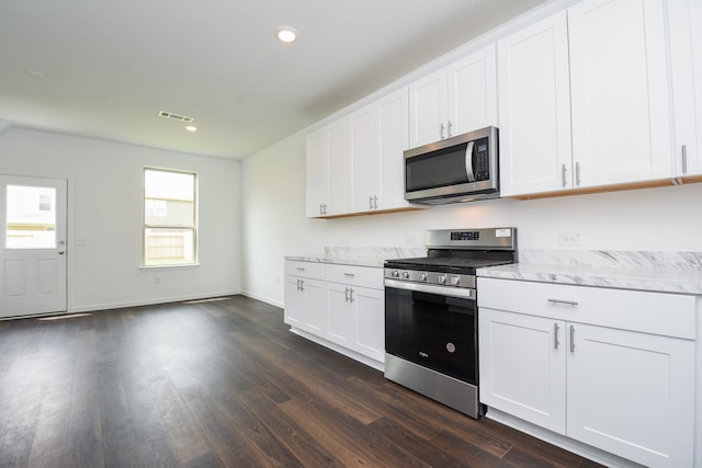 kitchen with light stone countertops, dark hardwood / wood-style flooring, stainless steel appliances, and white cabinetry