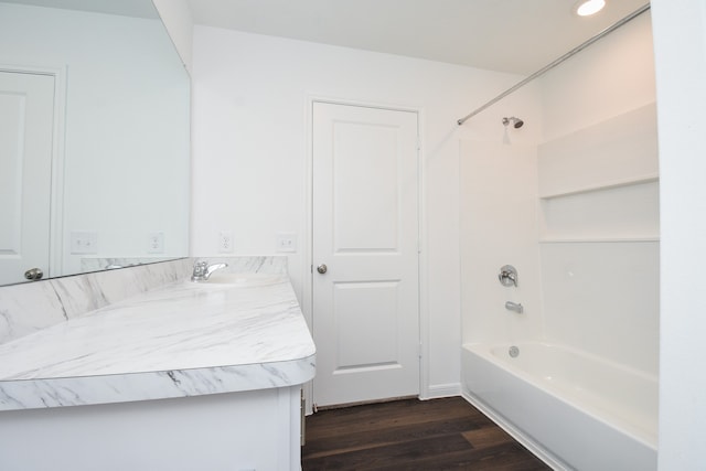 bathroom with hardwood / wood-style floors, vanity, and shower / washtub combination