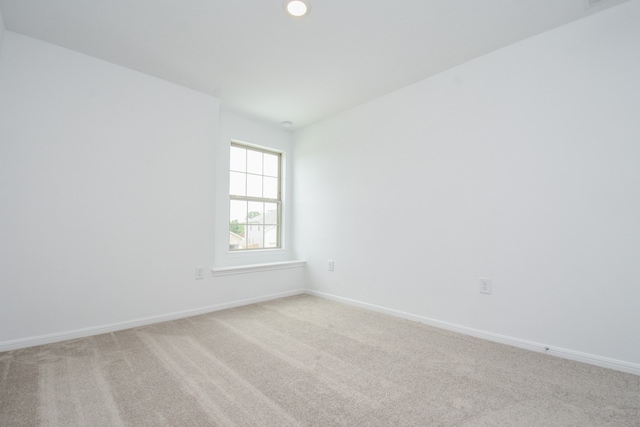 unfurnished room featuring light carpet