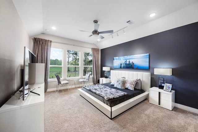 carpeted bedroom featuring ceiling fan, rail lighting, and lofted ceiling