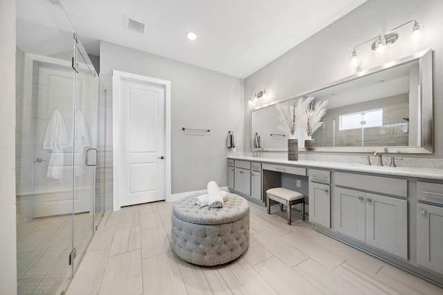 bathroom with vanity and a shower with door