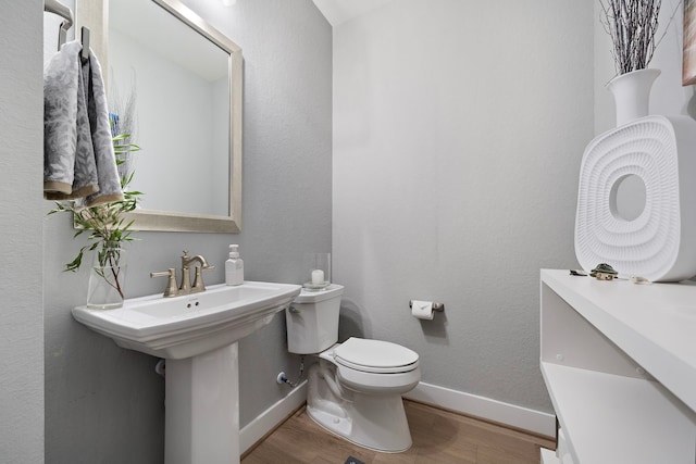 bathroom with hardwood / wood-style flooring and toilet