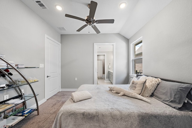 bedroom with ceiling fan, light colored carpet, lofted ceiling, and ensuite bath