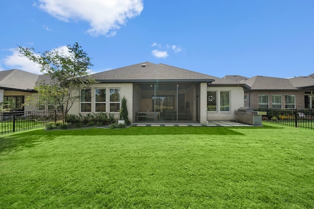 back of house with a lawn and a sunroom