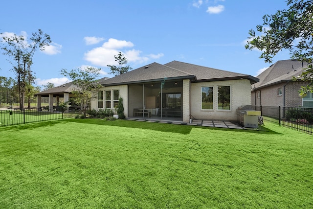 rear view of property featuring a yard and a sunroom