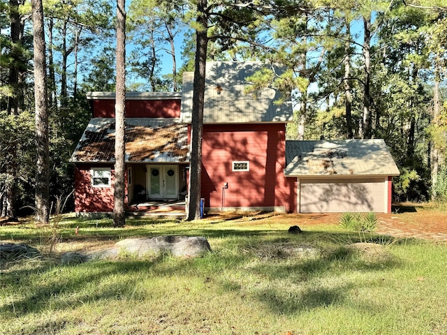 view of front of house with french doors, a front yard, and a garage