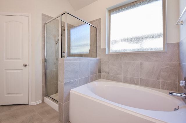 bathroom with tile patterned flooring and shower with separate bathtub