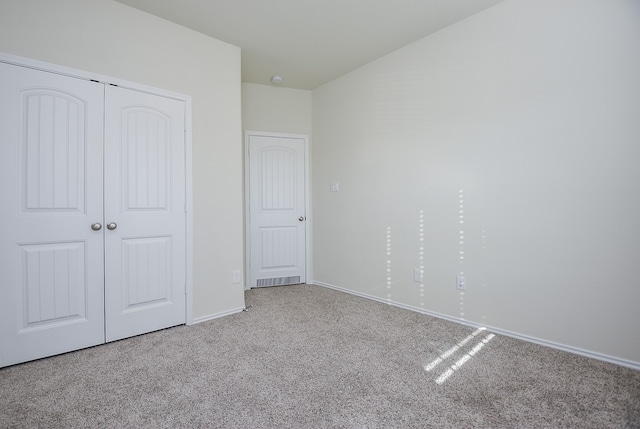 unfurnished bedroom with carpet and a closet