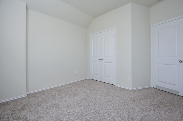 unfurnished bedroom with lofted ceiling and light carpet